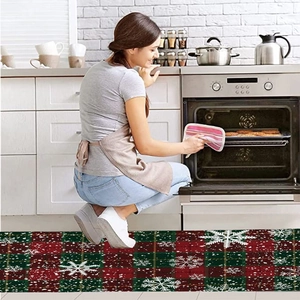 Detailed view of Christmas flannel kitchen mat featuring red green plaid and white snowflakes