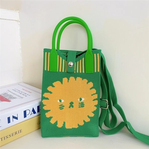 Detail of green knitted crossbody bag with cute lion face design and shoulder strap