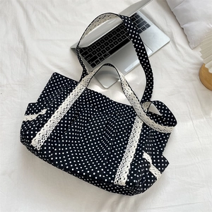 Detailed view of polka dot canvas tote bag with elegant white lace trim on the side