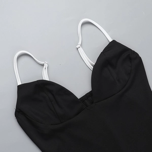 Detalle del vestido ajustado negro con tirantes blancos ajustables y costuras finas