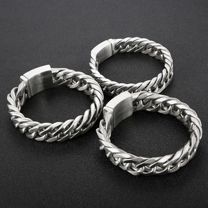 Close-up of three silver Cuban link bracelets with brushed stainless steel clasp