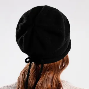 Women's black knit slouchy beanie with a delicate drawstring bow detail on the back