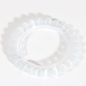 Macro shot of white cat eye bead bracelet with translucent finish and optic light effect