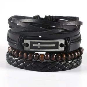 Detail of multi-layer leather bracelet featuring woven cords, wood beads, and a cross charm