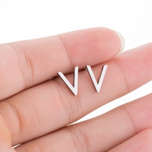 Close-up of V-shaped minimalist silver steel stud earrings held in hand for detail