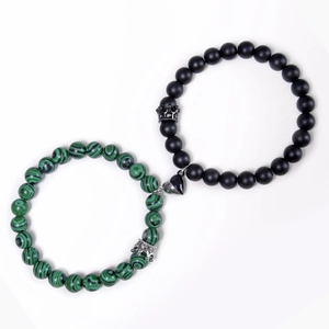 Detail of magnet heart clasp connecting matte black and turquoise beaded couple bracelets