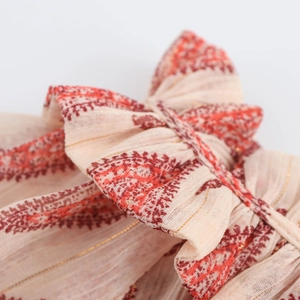 Detailed close-up of a chiffon bow tie on a beige metallic pinstripe vintage blouse