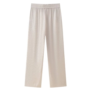 Detail einer cremeweißen Plissee-Hose mit weitem Bein und elastischem Bund mit Textur