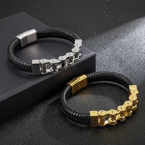 Detail of silver and gold men's braided leather bracelets with industrial gear metal link