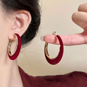 Minimalist C-shaped flocking hoops in burgundy and gold for a retro style