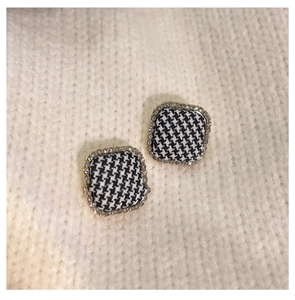 Detail of square houndstooth stud earrings with gold plating and sparkling crystal trim