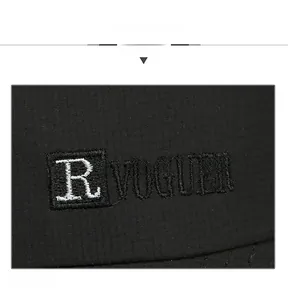 Close-up of R VOGUER letter embroidery on black breathable mesh baseball cap fabric