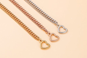 Close-up of heart charms and textured chains in gold, rose gold and silver finishes