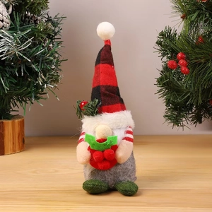 Detailed view of plush Christmas gnome with red plaid hat and berries on wooden table