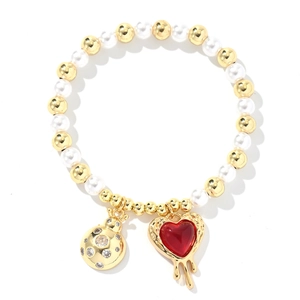 Detailed close-up of beaded bracelet with red heart pendant and gold zircon charm