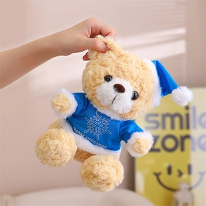 Close-up of brown teddy bear in blue Merry Christmas outfit with snowflake patterns