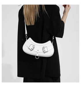 Detail of white leather crescent bag with metal buckle shown from a back perspective