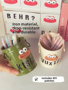 Detail of iron desk organizers in green and beige featuring cartoon mouth patches