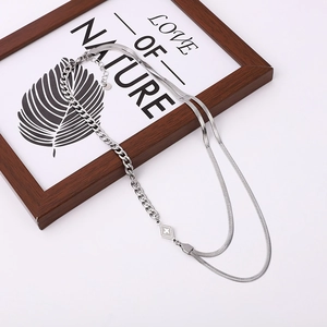 Close-up of silver double-layer chain with diamond star pendant and sleek snake bone link