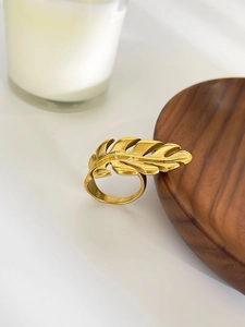 Detailed close-up of 18k gold plated stainless steel leaf ring on a wooden surface