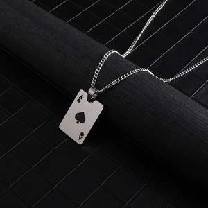 Detailed view of silver titanium steel ace of spades poker pendant on dark textured background