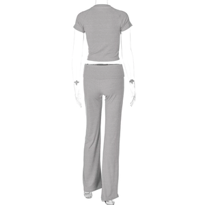 Vista posteriore del completo a due pezzi grigio in maglia con crop top e pantaloni donna