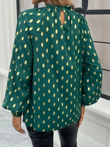 Back view of a green long-sleeved blouse with gold polka dots and high neck button closure