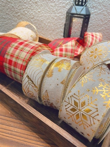 Detail of Christmas plaid and gold snowflake burlap ribbons on a rustic wood tray