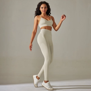 Detail of seamless ribbed beige yoga set featuring a cross-strap bra and high-waist leggings