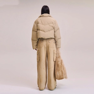Back view of a khaki short down jacket paired with cargo pants and a faux fur tote bag