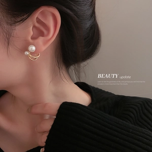 Minimalist gold C-shaped double ring earrings with pearls worn by a model