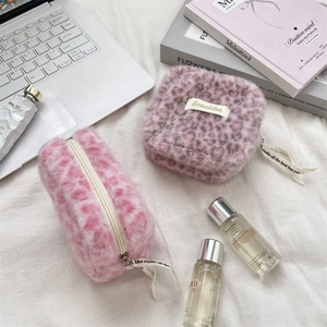 Plush leopard print pouches with Sorakkha label and ribbon detail on textured fabric