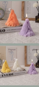 Detail of prayer girl scented candles with textured cloaks in orange, purple, and white