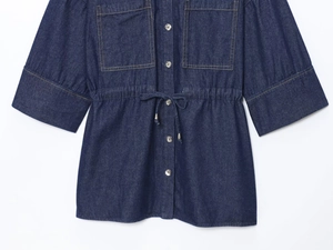 Detail of dark blue denim shirt with dual chest pockets and drawstring waist design