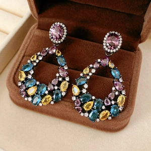 Dettaglio di orecchini vintage con cristalli viola e blu in una scatola per gioielli