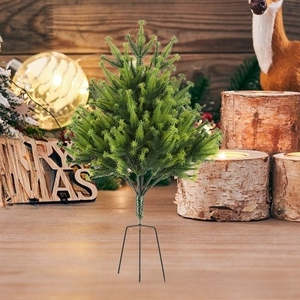 Close-up of artificial flocked Christmas tree needles with black metal tripod stand base