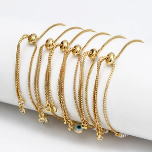 Bracciali regolabili dorati Evil Eye con catena a scatola e perle su supporto bianco