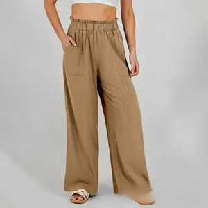 Dettaglio dei pantaloni ampi in lino kaki con vita elastica e grandi tasche laterali