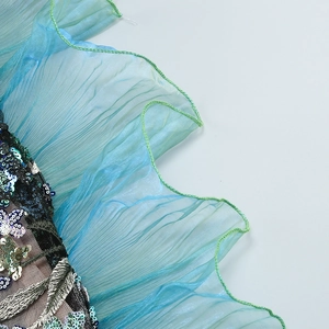 Vue détaillée des broderies à paillettes et du tulle plissé sur la robe bleu lac