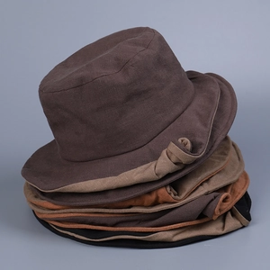 Stacked linen bucket hats for women in brown, caramel, and black with double-layered brims