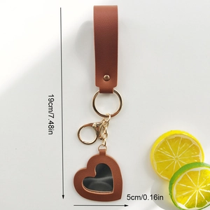 Brown heart-shaped leather mirror keychain with golden hardware, measuring 19cm in length