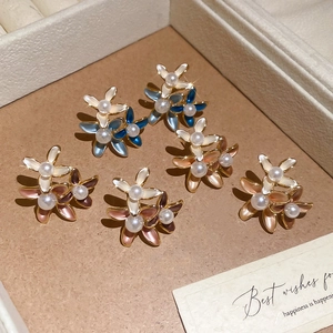 Detail view of 18K gold plated flower earrings with pearls and colorful enamel inlay