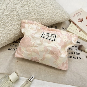 Detailed close-up of pink jacquard floral makeup bag with Pleasant Time fabric label