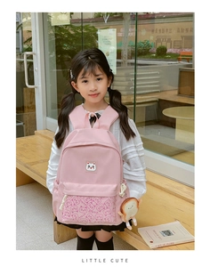 Pink children backpack with cat embroidery and plush toast charm in cafe setting