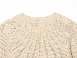 Détail de l'encolure d'un gilet en tricot beige montrant les coutures de qualité