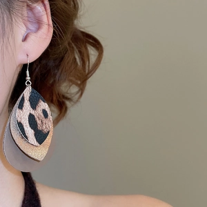 Detail of triple-layer leaf earrings featuring leopard print and gold glitter textures