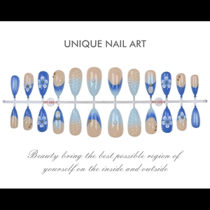 Macro di fiori 3D e perle su unghie finte blu sfumate con borchie dorate decorative