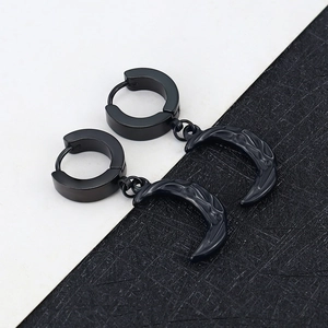 Macro detail of black titanium hoop earring with embossed crescent moon pendant texture