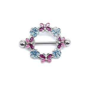 Close-up of silver nipple ring with pink and blue butterfly and flower rhinestones