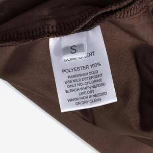 Gros plan de l'étiquette d'entretien indiquant la taille S et 100% polyester